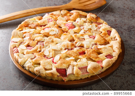 Scandinavian Rhubarb Cake with almond flakes closeup in the plate. Horizontal 89955668
