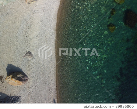 Aerial view on calm azure sea and volcanic rocky shores. Small waves on water surface in motion blur. Nature summer ocean sea beach background. Nobody. Holiday, vacation and travel concept Aerial view on calm azure sea and volcanic rocky shores. Small waves on water surface in motion blur. Nature summer ocean sea beach background. Nobody. Holiday, vacation and travel concept 89956800