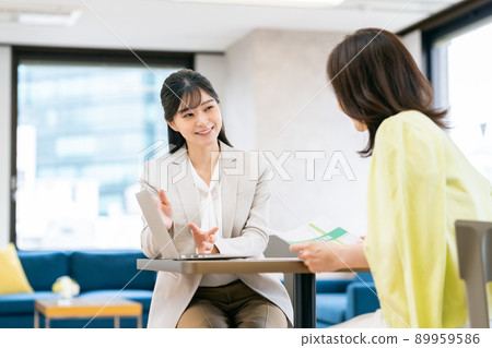 A young business woman explaining to a middle-aged woman 89959586