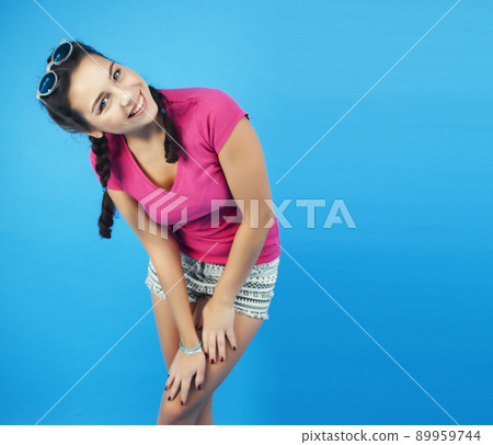 young pretty girl posing happy smiling on blue background, lifestyle people on summer vacation concept close up 89959744