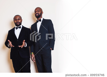 two african-american businessmen in black suits emotional posing, gesturing, smiling. wearing bow-ties close up 89959746