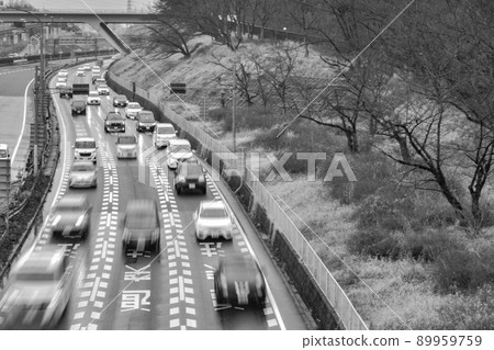 許多汽車在三車道公路上駛向這裡的黑白圖像 許多汽車在三車道公路上駛向這裡的黑白圖像 89959759