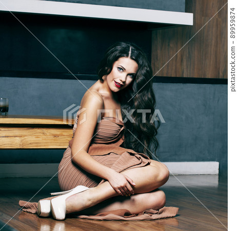 beauty young brunette woman sitting near fireplace at home, winter warm evening in interior, waiting to celebrate alone close up 89959874