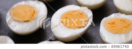 Boiled chicken eggs cut in half on dark background 89961740