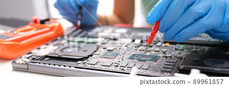 Laptop repair, hands hold voltage meter for electronics Laptop repair, hands hold voltage meter for electronics 89961857