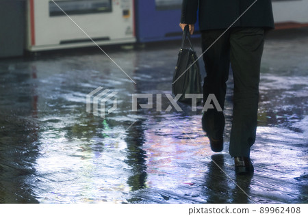 A businessman walking on a rainy night 89962408
