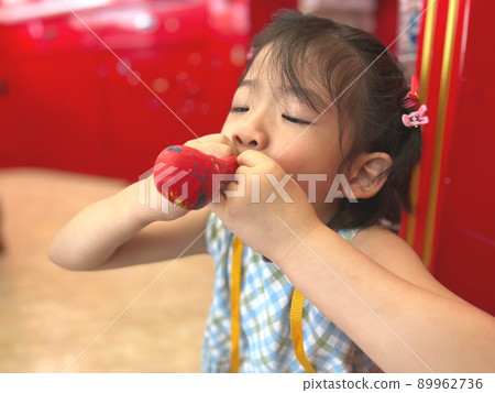 cute little girl tries to inflate a balloon cute little girl tries to inflate a balloon 89962736