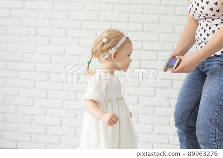 Child with cochlear implant hearing aid having fun with mother in room background with copy space and place for advertising - diversity and deafness treatment and medical innovative technologies Child with cochlear implant hearing aid having fun with mother in room background with copy space and place for advertising - diversity and deafness treatment and medical innovative technologies 89963276