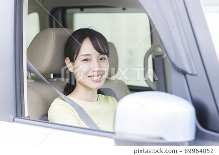 A young woman driving a car A young woman driving a car 89964052