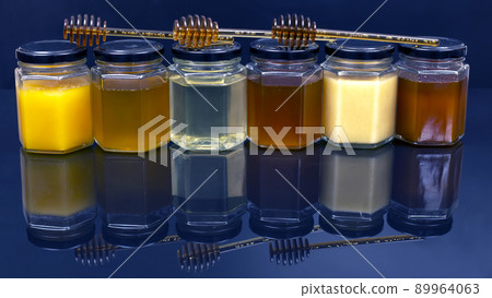 jars with different types and colors of honey on a white blue background. organic vitamin products 89964063