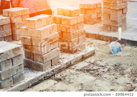 View of new paving slabs and concrete blocks on summer day at construction site. Stone blocks stand 89964452