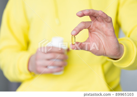 Male hand holding vitamins. Closeup. Healthcare and medicine. Male hand holding vitamins. Closeup. Healthcare and medicine. 89965103