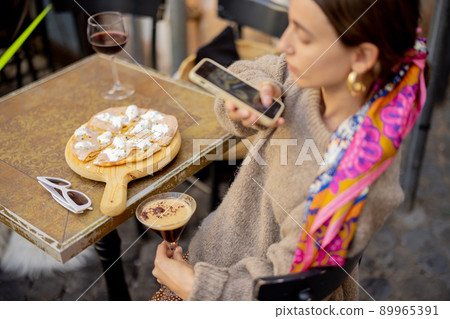 Woman taking photo of italian cuisine while travel in Italy Woman taking photo of italian cuisine while travel in Italy 89965391