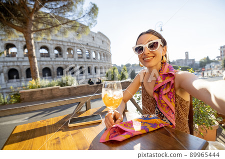Woman at outdoor cafe near Coliseum in Rome, Italy 89965444
