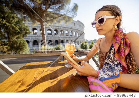 Woman at outdoor cafe near Coliseum in Rome, Italy 89965448