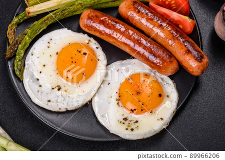 A delicious nourishing breakfast with fried eggs, sausages, asparagus, tomatoes, avocado, spices and herbs A delicious nourishing breakfast with fried eggs, sausages, asparagus, tomatoes, avocado, spices and herbs 89966206