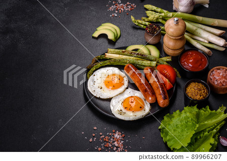 A delicious nourishing breakfast with fried eggs, sausages, asparagus, tomatoes, avocado, spices and herbs A delicious nourishing breakfast with fried eggs, sausages, asparagus, tomatoes, avocado, spices and herbs 89966207