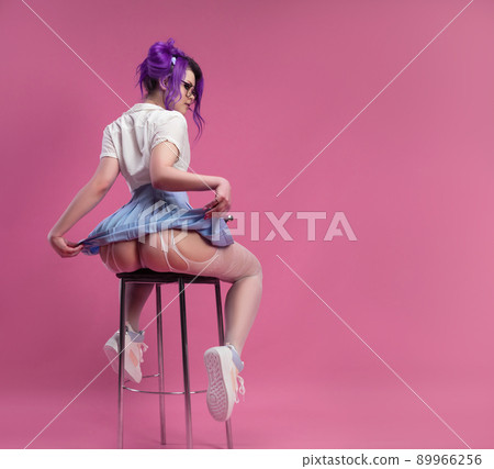 sexy girl with purple hair in summer clothes and beautiful underwear on a pink background 89966256