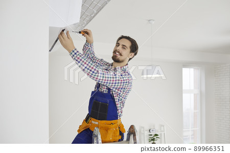 Professional repairman or technician using screwdriver while repairing air conditioner Professional repairman or technician using screwdriver while repairing air conditioner 89966351