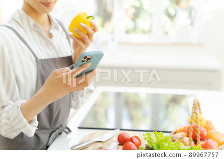Female kitchen with a smartphone 89967757