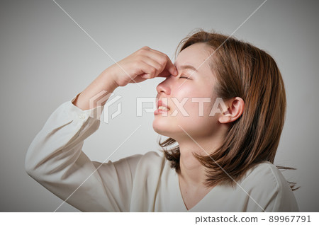 一個年輕的女人,她的眉毛疼痛,可以用手指握住它 一個年輕的女人,她的眉毛疼痛,可以用手指握住它 89967791