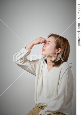 一個年輕的女人,她的眉毛疼痛,可以用手指握住它 一個年輕的女人,她的眉毛疼痛,可以用手指握住它 89967793