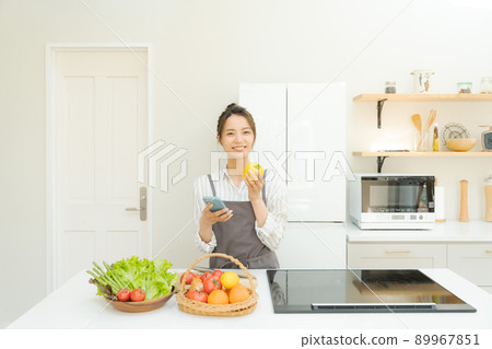 Female kitchen with a smartphone 89967851