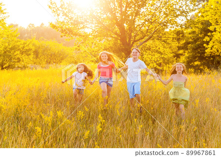 four happy beautiful children running playing moving together in the beautiful summer day. jumping and looking at camera with happiness and toothy smile. four happy beautiful children running playing moving together in the beautiful summer day. jumping and looking at camera with happiness and toothy smile. 89967861