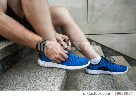 Profile. View from above. Close up blue sneackers. Tie shoelaces. Profile. View from above. Close up blue sneackers. Tie shoelaces. 89968034