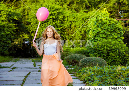 Portrait of happy girl with air balloon enjoying in the park on summertime. Portrait of happy girl with air balloon enjoying in the park on summertime. 89968099