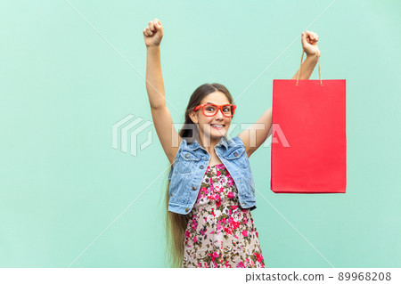 Very happyness beautiful long haired girl in casual clothing with shopping bags, looking at camera. Blonde model. Sales, shop, retail, consumer concept. Isolated studio shot on light blue background 89968208