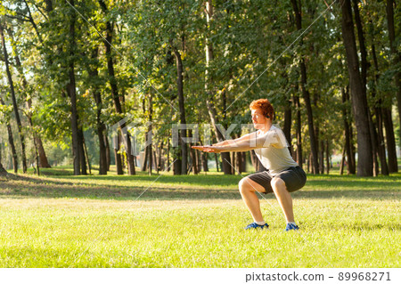 Sit ups. Young adult redhead man having intensive training outdoors in morning 89968271