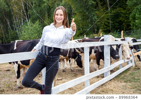 Close up. Like, thumbs up. Walking and have a fun time in milk farm. Happiness girl thumbs up, looking at camera and smiling. Outdoor 89968364