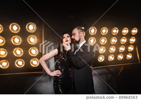Romantic style portrait of an elegant couple in the night club. Businessman touching chin beautiful redhead woman.Studio shot Romantic style portrait of an elegant couple in the night club. Businessman touching chin beautiful redhead woman.Studio shot 89968563
