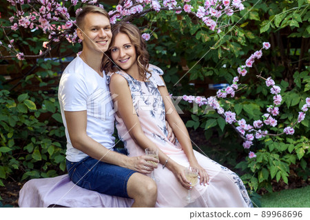 Handsome happiness couple posing near the sakura. Outdoor shot, spring park or summer concept. Love, sensual people Handsome happiness couple posing near the sakura. Outdoor shot, spring park or summer concept. Love, sensual people 89968696