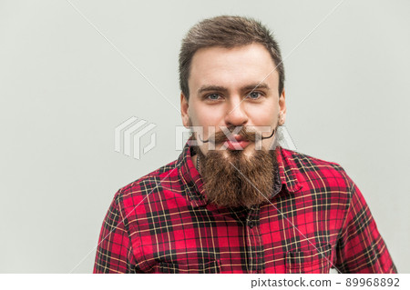 Air kissing and flirt. Close up. Portrait of funny bearded man. Gray background, studio shot 89968892