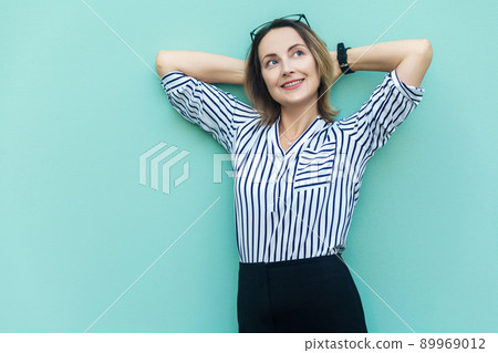 Relaxation concept. Happiness and beautiful business woman, holding hand near head and relax. Light blue background Relaxation concept. Happiness and beautiful business woman, holding hand near head and relax. Light blue background 89969012