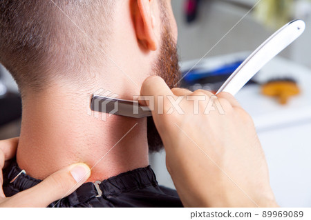 Man having a shave at the barber shop. Man having a shave at the barber shop. 89969089