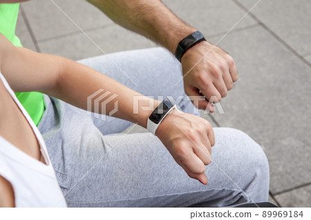 Two people using smart sport watch at workout. Two people using smart sport watch at workout. 89969184