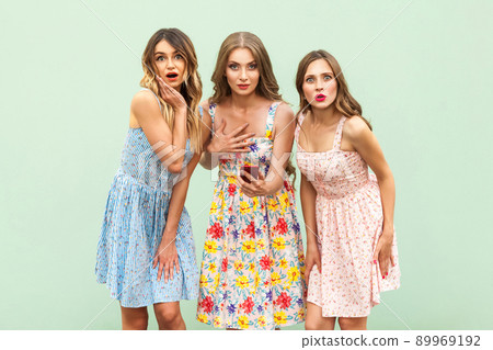 People emotions and feelings. Wonder, shock, surprised. Three young adult pretty fashion model looking at camera with shocked face and big eyes. Very surprised. Studio shot on green background People emotions and feelings. Wonder, shock, surprised. Three young adult pretty fashion model looking at camera with shocked face and big eyes. Very surprised. Studio shot on green background 89969192