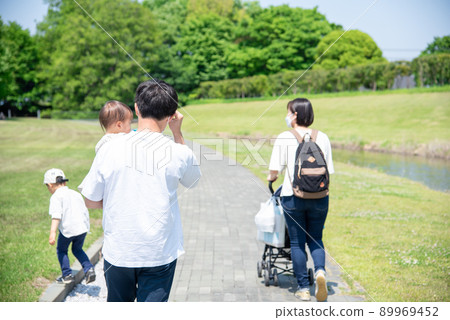 A family of four walking towards the park A family of four walking towards the park 89969452