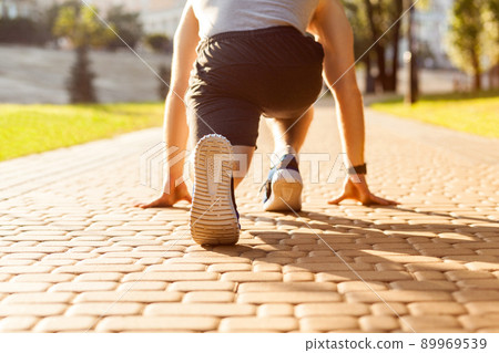 Runner in park. Young athletic man jogging at morning. Low star. Fitness model in crossfit exercise outdoors. Healthy lifestyle concept. Runner in park. Young athletic man jogging at morning. Low star. Fitness model in crossfit exercise outdoors. Healthy lifestyle concept. 89969539