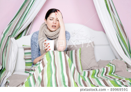Young beautiful sick woman feeling ill and bad lying on bed suffering headache and temperature trying to rest and sleep on bed. Young beautiful sick woman feeling ill and bad lying on bed suffering headache and temperature trying to rest and sleep on bed. 89969591
