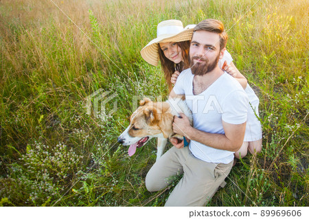 Happy beautiful couple with their Alabai dog in nature with sunset. 89969606