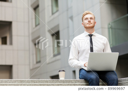Imagination and dreaming concept. Young adult businessman working outsourcing and wondering . Outdoor Imagination and dreaming concept. Young adult businessman working outsourcing and wondering . Outdoor 89969697