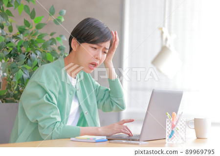 A woman who finds a mistake in work and holds her head 89969795