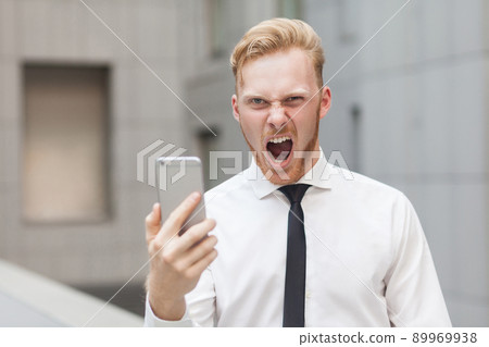 Crazy roar and looking at camera. Red head businessman. Close up, focus on face Crazy roar and looking at camera. Red head businessman. Close up, focus on face 89969938