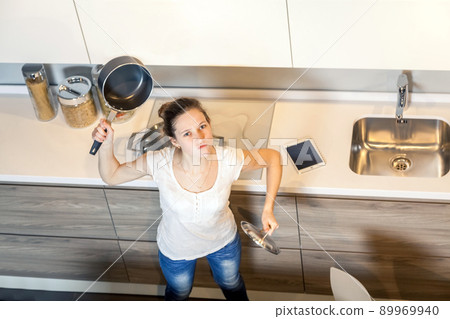 Mad and crazy housewife woman with kitchen pan. top view. looking at camera. 89969940