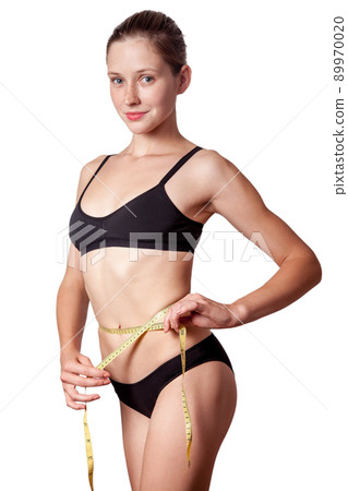 Slim fit happy young woman with measure tape measuring her waist with black underwear, isolated on white background. studio shot. Slim fit happy young woman with measure tape measuring her waist with black underwear, isolated on white background. studio shot. 89970020