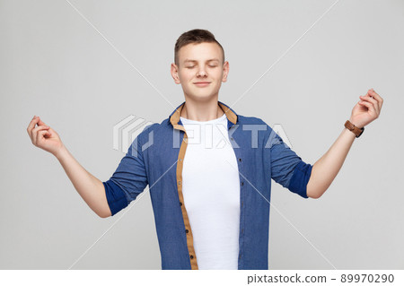 Harmony concept. Boy closed eyes, doing yoga and have a happiness look. Studio shot 89970290